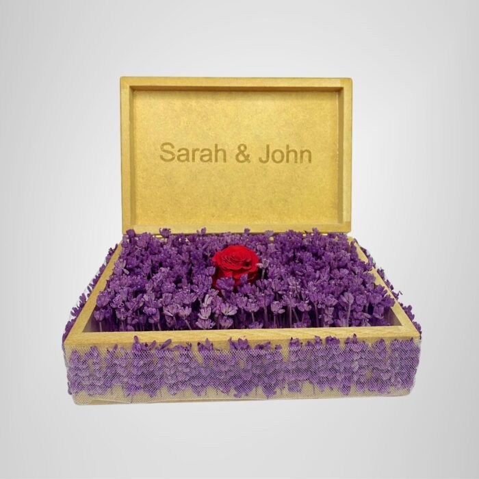 Personalized wooden flower box with "Sarah & John" engraving in Courier New font (2 cm height), filled with vibrant purple real preserved lavender and a single preserved red rose. Ideal for romantic gifts, weddings, anniversaries, birthdays, or special occasions, this handcrafted keepsake box measures 21 cm L x 14 cm W x 7 cm H. The natural wood finish and aromatic lavender make it a timeless gift for couples to cherish forever. Crafted with love by Sear Handcrafted Elegance.