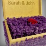 Full view of a personalized wooden flower box engraved with "Sarah & John," featuring purple lavender and a preserved red rose. A perfect romantic gift or keepsake by Sear Handcrafted Elegance.