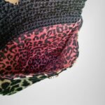 Sear Handcrafted Elegance brand handmade leopard print black crochet clutch bag, inside view. Features a vibrant pink leopard print lining, showcasing elegant craftsmanship and attention to detail.