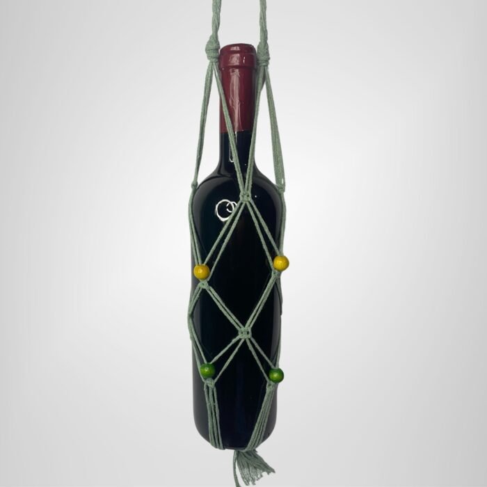A Sear Handcrafted Elegance macrame wine bottle bag in green, handmade from 100% recycled cotton, holding a wine bottle. The bag features an intricate knot design with green and yellow decorative beads and a tassel at the bottom, displayed against a plain background.