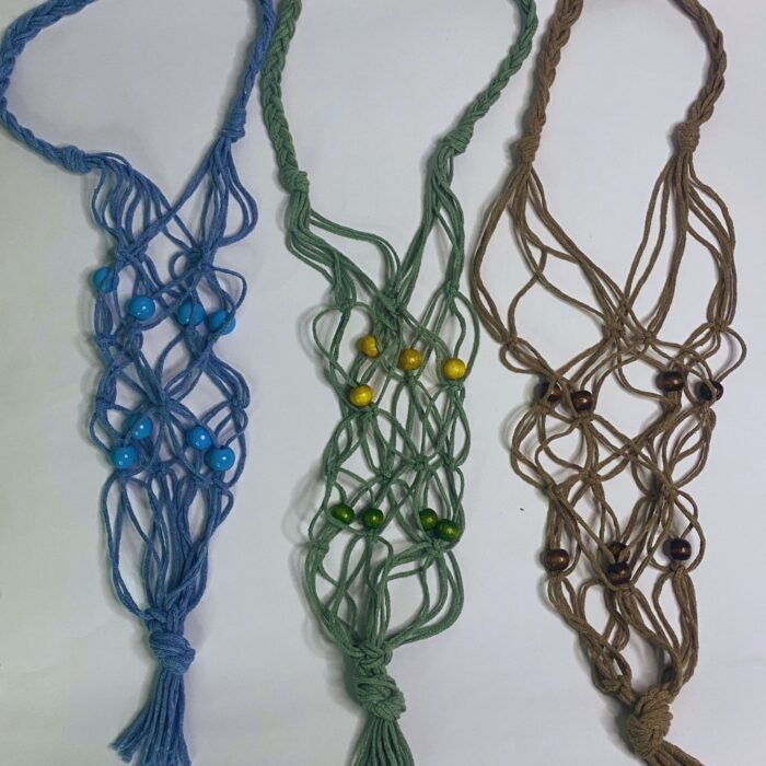Three Sear Handcrafted Elegance macrame wine bottle bags, handmade from 100% recycled cotton, in blue, green, and beige. The bags are laid flat, showcasing their intricate knot designs and decorative beads in blue, green, and brown, against a plain background.