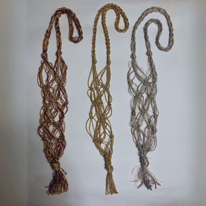Three Sear Handcrafted Elegance sim macrame wine bottle bags, handmade with shimmering threads, in gold, silver, and red. Each bag features an intricate knot design with a sparkling finish and tassels, displayed flat against a plain background.