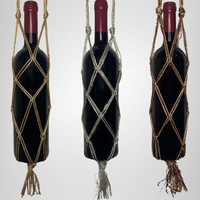 A Sear Handcrafted Elegance sim macrame wine bottle bag, handmade with shimmering threads, displayed in three colors: gold, silver, and red. Each bag holds a wine bottle, showcasing intricate knot designs with a sparkling finish and tassels, against a plain background.