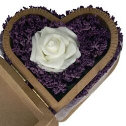 Close-up of an artificial white rose and real lavender flowers in a heart-shaped wooden box, highlighting delicate details and natural beauty.