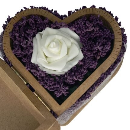 Close-up of an artificial white rose and real lavender flowers in a heart-shaped wooden box, highlighting delicate details and natural beauty.