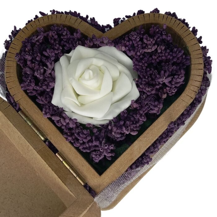 Close-up of an artificial white rose and real lavender flowers in a heart-shaped wooden box, highlighting delicate details and natural beauty.