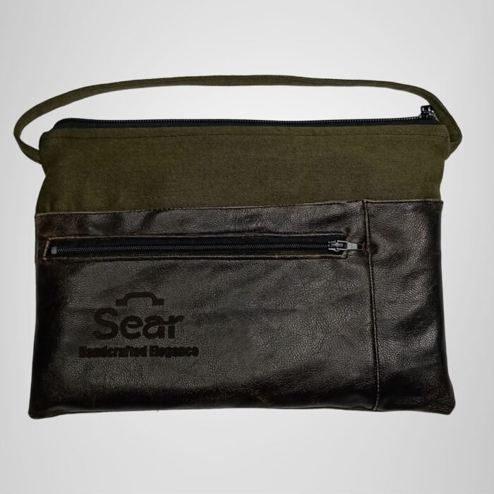 Green and black leather handbag with front pocket detail, modern design. Features the Sear Handcrafted Elegance logo.