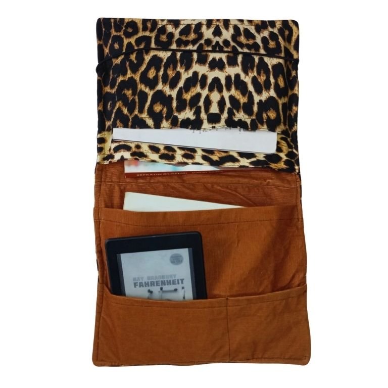 Interior view of a leopard print organizer bag, featuring brown pockets with an e-reader and books. Category image.